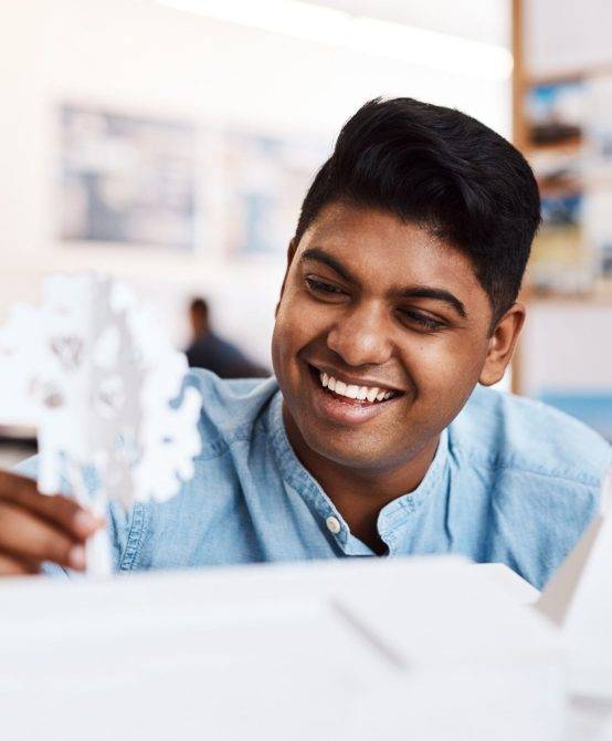 Shot of a young architect designing a building model in a modern office. Shot of a young architect designing a building model in a modern office.